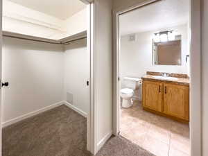 Bathroom with toilet, baseboards, visible vents, and vanity