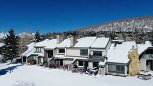 View of front of house featuring a mountain view, a chimney, and a balcony