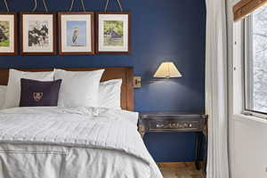 Bedroom featuring multiple windows and wood finished floors