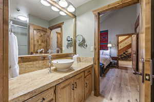 Bathroom featuring wood finished floors, connected bathroom, and vanity