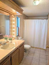 Bathroom with toilet, tile, and vanity