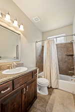 Bathroom with tile patterned floors, visible vents, toilet, shower / bath combo, and vanity
