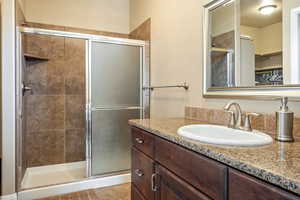 Full bath featuring vanity and a shower stall