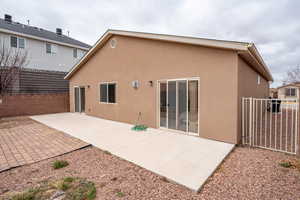 Back of property with stucco siding, fence, and a patio area