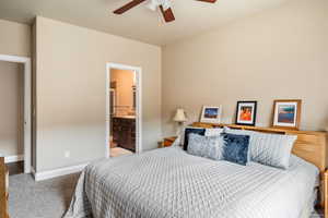 Bedroom with ceiling fan, baseboards, connected bathroom, and carpet