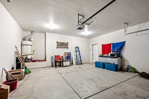 Garage featuring a garage door opener and baseboards
