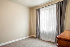 Carpeted empty room featuring baseboards