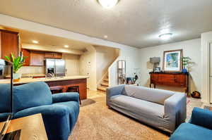 Living room featuring recessed lighting, light carpet and stairs