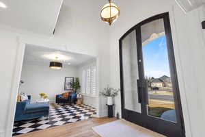 Foyer entrance with baseboards, ornamental molding, wood finished floors, and french doors