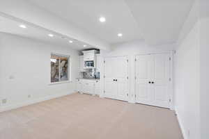 Interior space with recessed lighting, light colored carpet, and baseboards