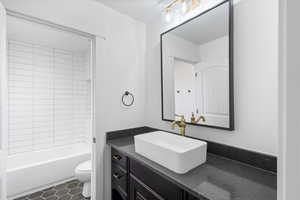 Full bath with shower / tub combination, tile patterned flooring, vanity, and toilet