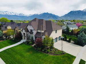 Exterior space featuring an attached garage, driveway, stone siding, and a mountain view