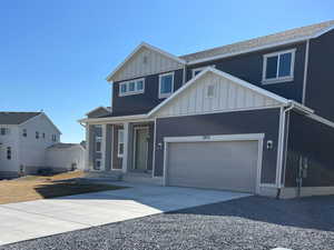 View of front of home featuring an attached garage, board and batten siding, and driveway