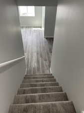 Stairway with baseboards and wood finished floors