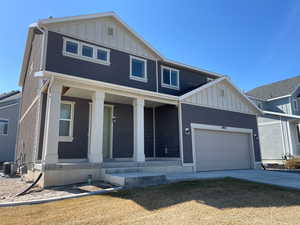 View of front of home with cooling unit, driveway, a porch, a garage, and board and batten siding