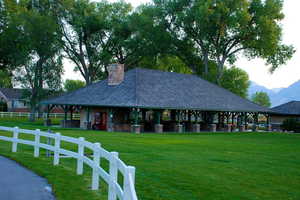 View of community featuring a mountain view, a lawn, and fence