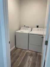 Laundry area featuring independent washer and dryer, wood finished floors, laundry area, and baseboards