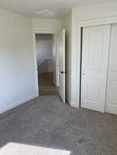 Unfurnished bedroom with a closet, visible vents, baseboards, and carpet floors