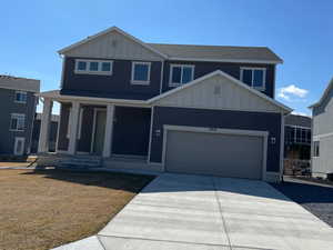 View of front facade featuring a garage, board and batten siding, and driveway