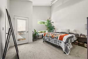 Carpeted bedroom featuring a high ceiling