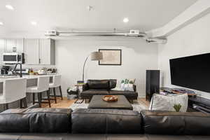 Living room featuring recessed lighting, visible vents, baseboards, and light wood-style flooring