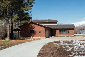 View of front of home with brick siding, concrete driveway, and a garage