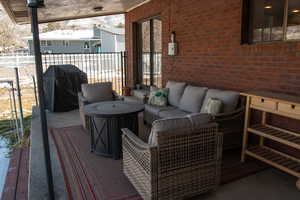 View of patio featuring an outdoor living space, a grill, and fence