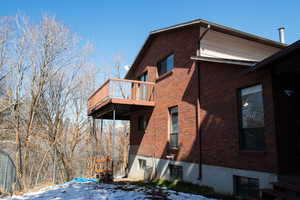 West side of property featuring a balcony and brick siding