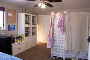 Bedroom featuring a textured ceiling, ceiling fan,  and his and her closets