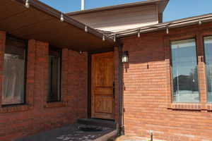 Property entrance featuring brick siding