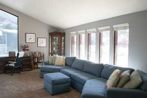 Living room with lofted ceiling and carpet floors