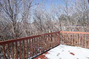 View of snow covered deck off larger bedroom on 2nd story. Perfect for watching the sunrise or sunset.