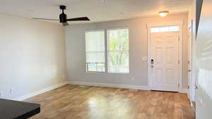 Foyer entrance featuring light wood-style flooring, baseboards, and a ceiling fan