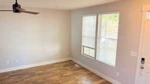 Spare room featuring visible vents, baseboards, ceiling fan, and wood finished floors