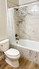 Full bathroom with shower / bath combination with curtain and toilet