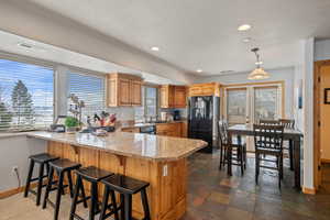 Kitchen featuring recessed lighting, a peninsula, visible vents, baseboards, and black appliances