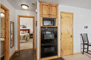 Kitchen with black appliances, baseboards, visible vents, and washer / clothes dryer