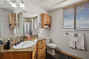 Full bathroom with toilet, baseboards, a shower with shower curtain, and vanity