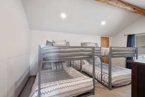 Carpeted bedroom with lofted ceiling with beams, recessed lighting, and baseboards