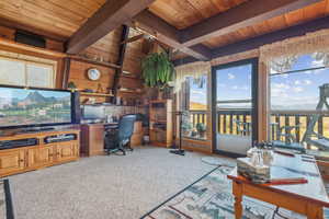 Carpeted office with beamed ceiling, wooden walls, and wooden ceiling