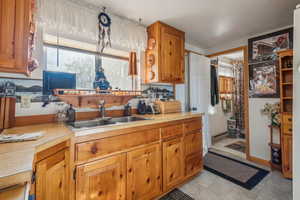 Kitchen with a baseboard heating unit, light countertops, brown cabinetry, and a sink