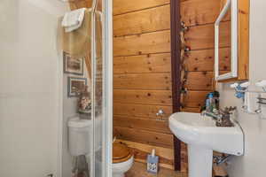 Full bathroom featuring tile patterned floors, toilet, and a stall shower