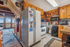 Kitchen featuring black appliances, a toaster, and open shelves