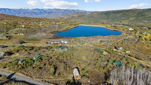 Birds eye view of property with a water and mountain view