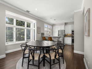 Dining room with visible vents, baseboards, and crown molding