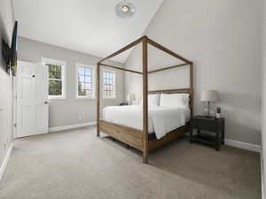 Carpeted bedroom featuring baseboards and lofted ceiling