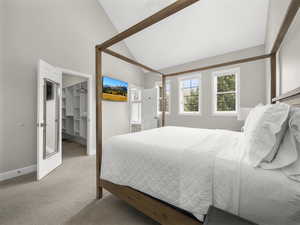 Carpeted bedroom featuring a closet, baseboards, high vaulted ceiling, and a spacious closet