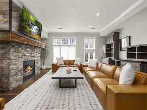 Living area with visible vents, crown molding, recessed lighting, a fireplace, and wood finished floors