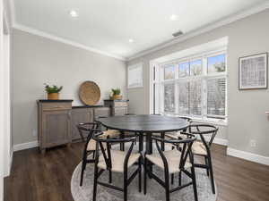 Dining space featuring visible vents, baseboards, and ornamental molding
