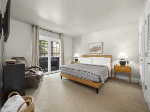 Bedroom with access to exterior, carpet flooring, and baseboards